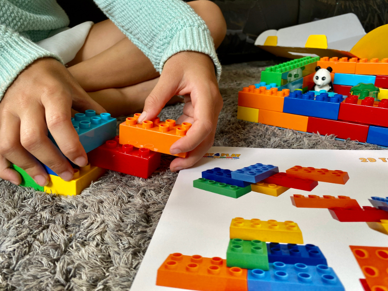 A young child exploring a hands-on building and pattern activity